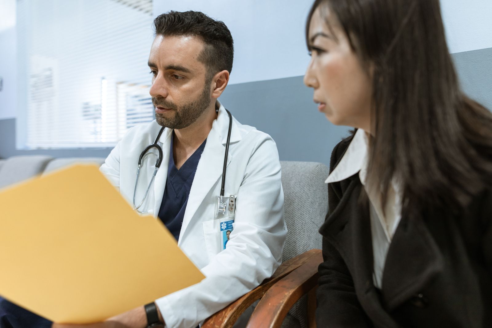 Doctor reviewing a patient's records folder during a consultation