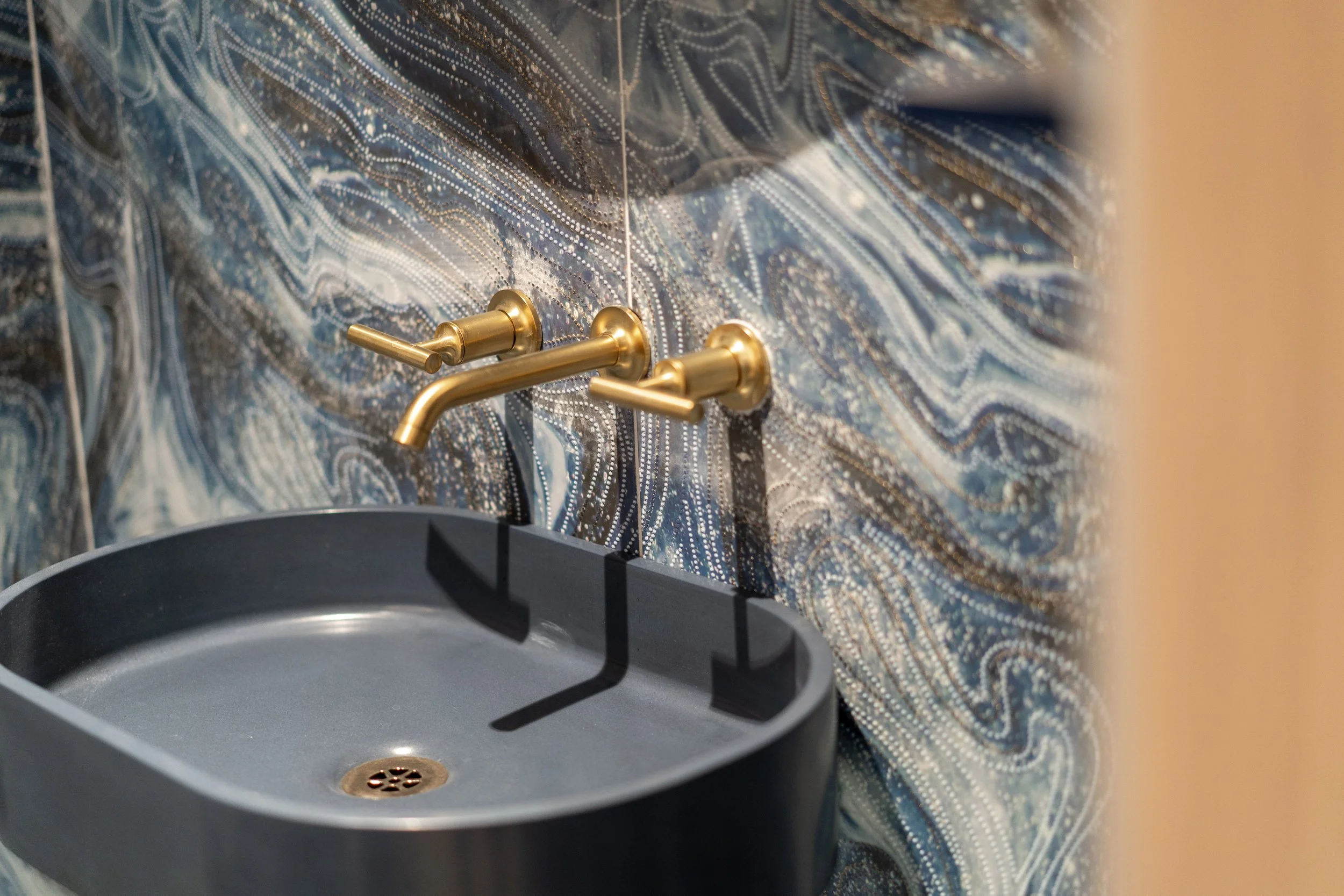 Modern bathroom with illuminated mirror and gold faucets