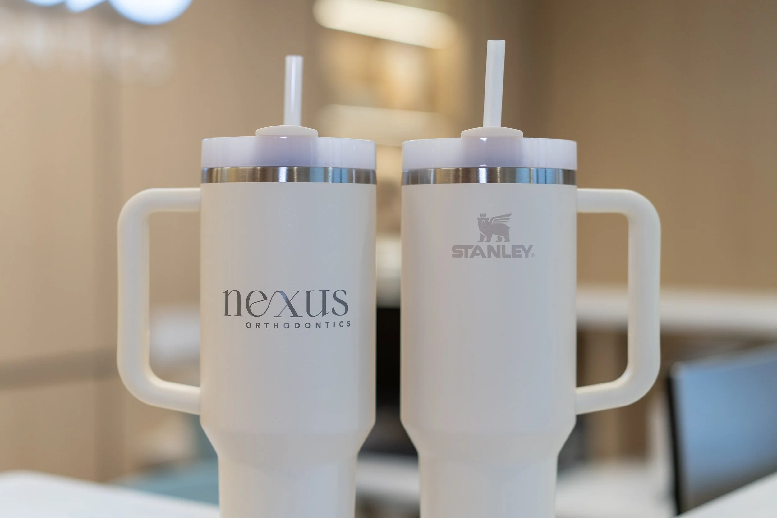 Stanley tumbler with dental items on a Nexus tote bag